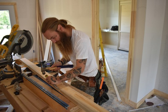 After knocking the cut wood out of the notch, a crew member uses a sharp chisel to finish the notch.