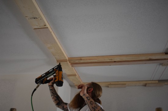 To make the depth of the main beam work out with the thickness of the panels as well as the various finish layers, the major beams have to be blocked down 1 inch. Here a crew member attaches a layer of 1/4-inch plywood followed by a layer of 3/4-inch plywood. 
