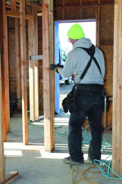 Using wedges to hold the boards apart, the author clips nails to remove a jack stud.