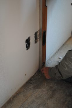 To provide electrical-box locations after the panel is raised, the author plumbs down from each box with a level, marking the locations on the floor.