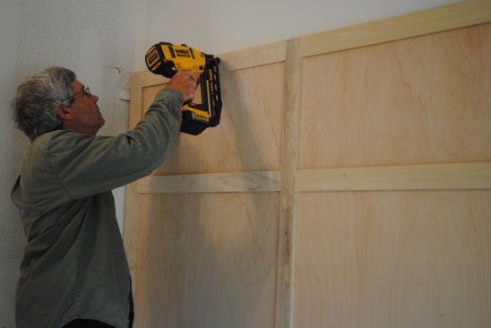 Once the author has positioned the panel assembly on the wall, the author nails it to the wall framing. 