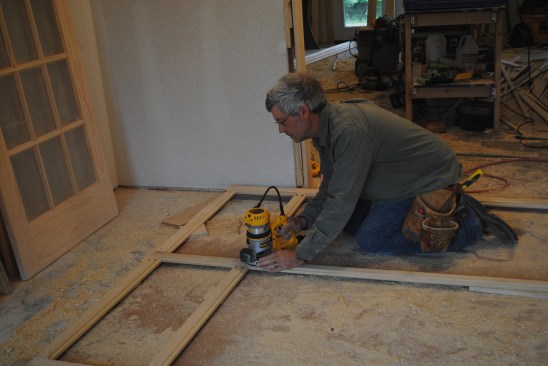 With the frame face down on the floor, the author routs the back side of the frame for the flat panel. 