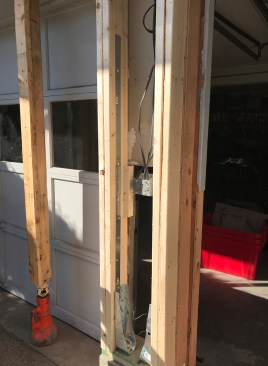 Flat straps attached with structural screws to the hold-downs and to the inside faces of the support studs reinforce the framing assembly.
