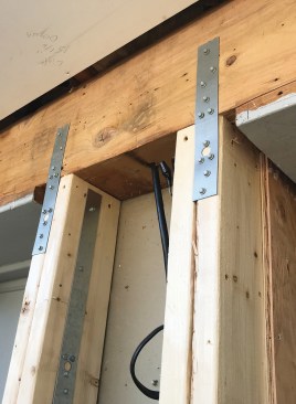 At the top, shorter straps reinforce the connection between the studs and the header.