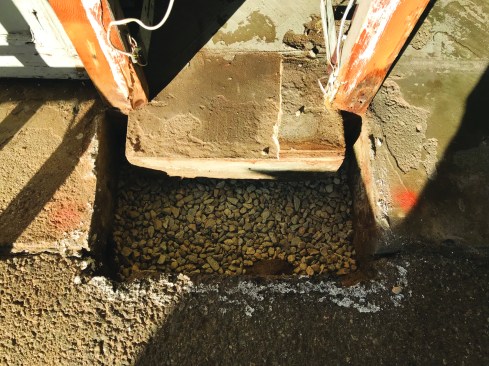 The author cleaned away the rotted wood, dug out the hole, and added a layer of crushed stone.
