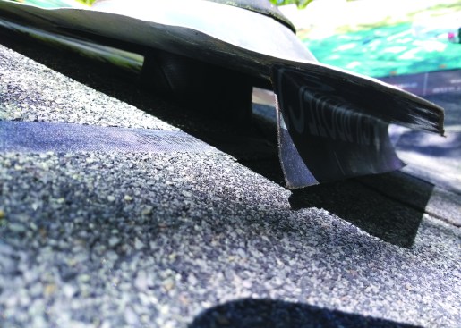 Slip the boot over the vent pipe and press the remaining flap of tape onto the shingles.