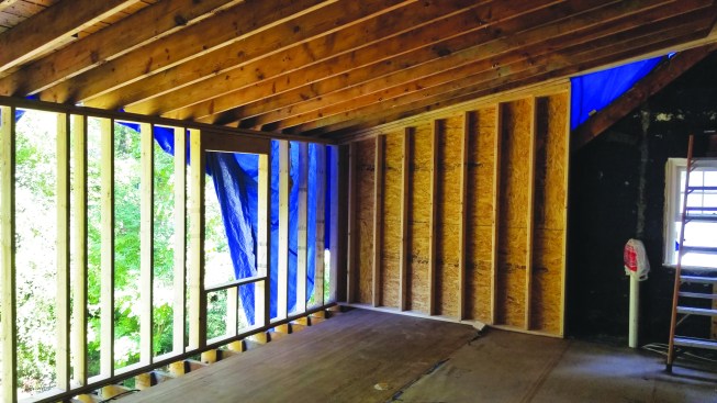 The crew installed squash blocks along the floor joists to support the plate for the dormer wall. They also built and raised cheek walls at the ends of the dormer.