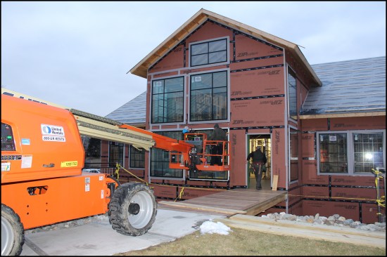 The four large south-facing window units are installed counterclockwise from the top right. Here, the last of the 7'-0" x 6'-0" entry windows is installed. Four smaller, 420-pound fixed windows on the east and west walls (two per wall), as well as a window unit high in the gable-end wall, were installed on the previous days.