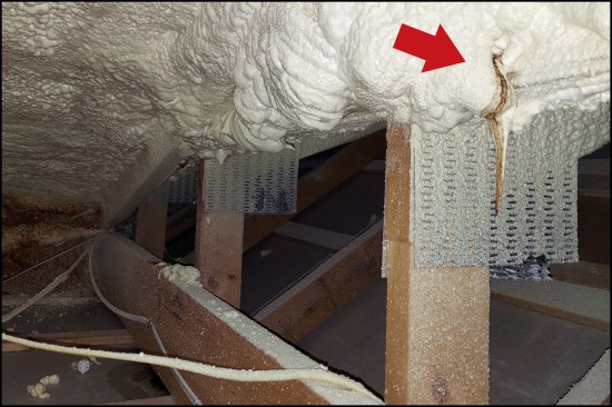 Here, “tea-staining” leaking from above indicates where moisture transported by warm air flowing through cracks between the foam and the framing has condensed on the roof sheathing.