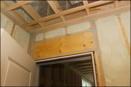 Above, the door header, jack, and king framing of an attached, unheated garage has been air-sealed with a quality sealant. Seemingly small, unsealed gaps between framing members become significant pathways when depressurization happens in the home via appliances such as dryers and range hoods.