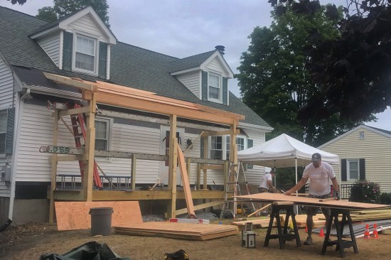 After clearing the front foundation of shrubbery and demoing the existing masonry stoop, DBS Remodel crew members poured the three support piers, then framed the new 7-foot-by-18-foot porch.