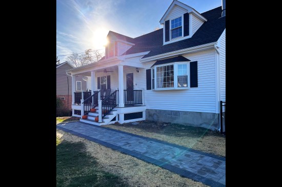 To complete the welcoming front porch on the homeowner’s renewed Cape Cod–style home, a hardscape walk was laid from the driveway to the stairs.