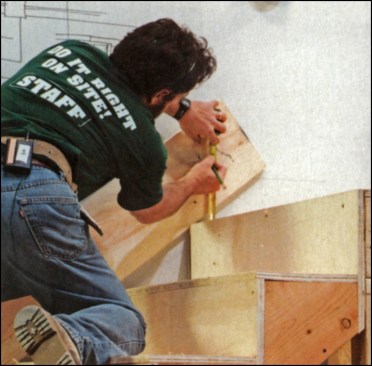 Figure 4: To notch the wall skirt around the landing framing, the author tacks the wall skirt along the nosings of the rough treads and marks a level line one standard rise above the landing floor.