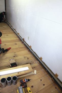 A chalk line snapped across the floor keeps the base blocks in a straight line.