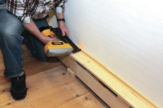 A thin strip of wood covers the gap between the top board and the uneven surface of the barn wall.