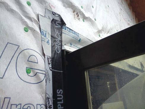 This is a good example of a common installation mistake called reverse shingling. The flashing incorrectly laps over the Tyvek (rather than vice versa), and jamb flashing incorrectly laps over the head flashings.