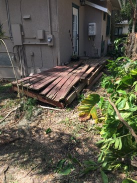 The stump of the tree that had fallen during the storm can be seen to the right of the damaged deck.