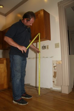 He also checks for the same issues along the front plane of the cabinet run to get a sense of how much he’ll need to shim and what will happen to the toekick height once it’s scribed to the floor.