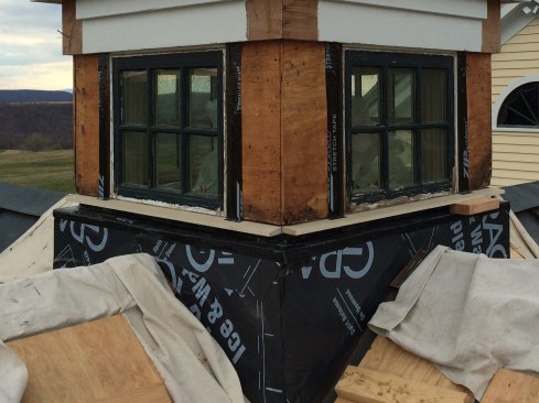 We covered the base sheathing with peel-and-stick, lapping the existing copper roof-to-wall flashing. Zip System Stretch Tape was used to seal the base’s 2-inch-wide step-out, then we dry-fit a new “through-sill” to help determine the finish elevation of the top of the cupola base. See detail 2.