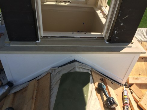 A wrap-around sill, formed from 2-by Boral stock, was installed. We fastened it only at the mitered corners and set it in sealant, providing gaps in the sealant for drainage. Then, we installed Boral “through-sills” on top of the wrap-around sill, which we butted up against the existing awning’s altered frame. See detail 2.