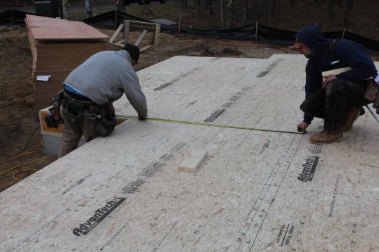 The crew measures up from the secondary baseline for the end of the one of the front walls of the house.