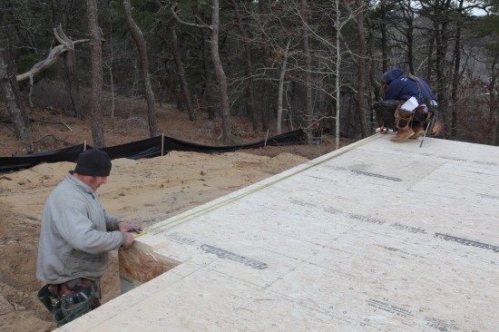 Crew members measure up from the original baseline to mark the position of the last short jog. This mark also sets the length of the perpendicular wall.