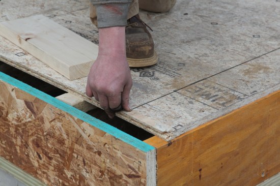 Here, the chalk line is held on the adjusted mark. Note that the mark was moved over about 1/4 inch to make this wall perpendicular to the baseline wall.