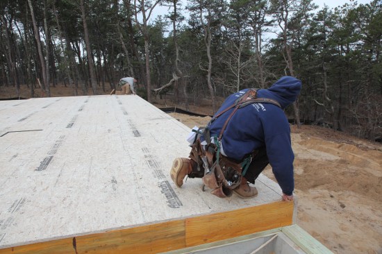 With the first corners established, the crew snaps a chalk line for the baseline wall. Black chalk holds up best during the framing process.