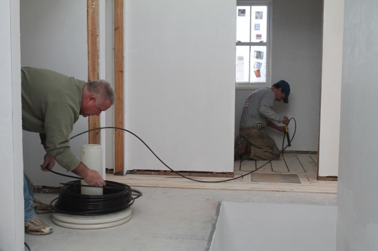 To install the tubing, one person uncoils it while another presses it into the grooves with a soft hammer handle. Occasionally, a block has to be used to seat the tubing properly.