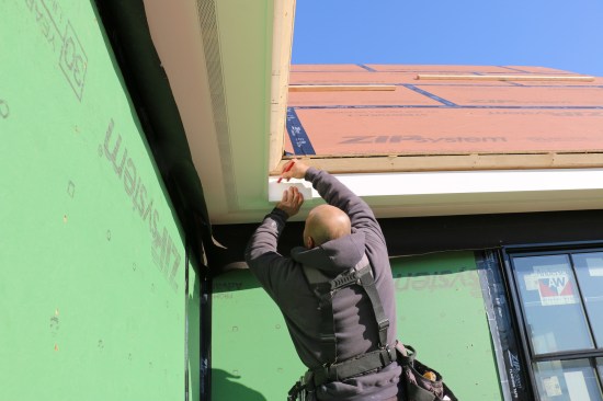 Using a gauging block to draw a line for the bottom of the crown molding ensures its accurate placement.
