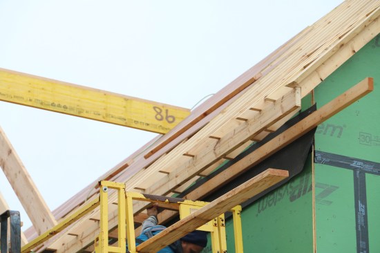 The subfascia fits into the notch cut into the rafters, and the soffit ledger attaches to the wall over a layer of 30-lb. felt paper.