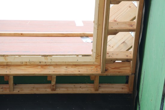 Blocking next to each rafter spans between the subfascia and the ledger. The angled crown backer fits against the subfascia and the horizontal cut of the rafters. The backer is mitered at all inside and outside corners.