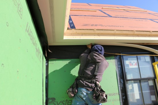 Rips of 3/8-inch-thick PVC flank the plastic vent strip for the soffit finish on the level eaves. The outer edge of the soffit overhangs the subfascia by 1/4 inch.