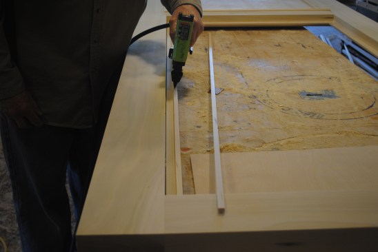 To make up for the thickness difference between the glass and the plywood,  a thin strip attaches to the back of the glass molding.