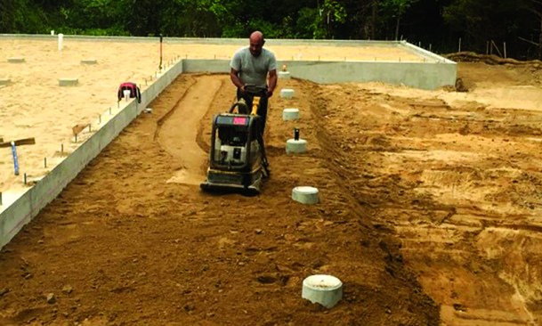 As the crew compacted the final grade, they sloped it away gradually from the foundation.