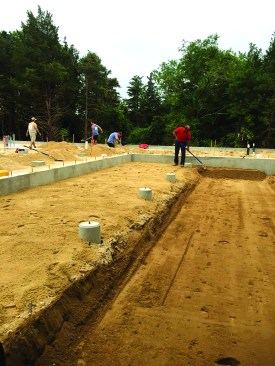 The grade drops just beyond the footings, for the ground gutter.