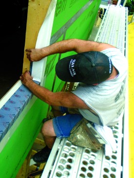 The sides of the opening are flashed in two pieces. The bottom piece laps over the sill flashing.