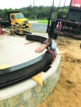 The steel fabricator sent out the beams to be rolled into the curve, then brought them to the site to check the layout and mark column positions on the top of the beam.