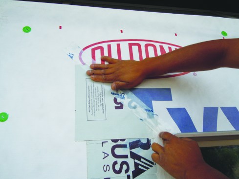 Sealing the WRB. With both strategies, the WRB head flap folds down over the SAF at the head of the window. Flashing tape seals the flap to the head flashing.