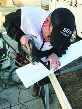 The sill has horns on the sides that fit under the side casings, and the author cuts them out with a jigsaw.