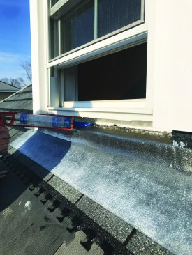 After the foam insulation cures, he applies a thick bead of clear silicone sealant to bed the sill in place.