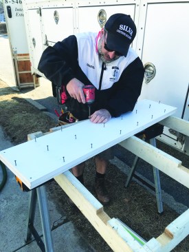 Then he drives screws to join the two sections together while the adhesive sets.