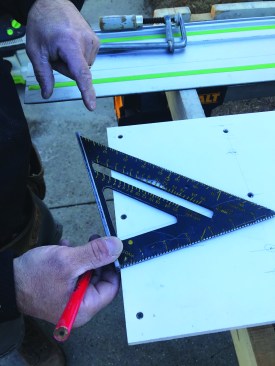 Next, he places a rafter square on the line to find the angle measurement for setting the saw blade.