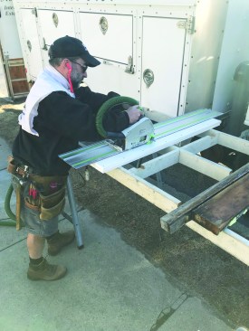 With the track saw set at the proper angle, the author makes the plumb cut for the edge of the windowsill.