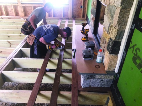 When there’s a fireplace (or similar structure) that the decking layout has to accommodate, the crew first establishes the overall layout, then determines the width of the picture frame around that structure based on the layout.