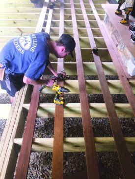 After predrilling, a crew member tacks the decking on the snapped lines.