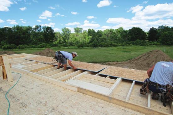 After squaring the wall, the crew snaps a chalk line across the studs to guide sheathing placement.