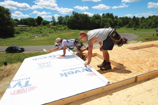 It's much easier to staple housewrap to the sheathing before raising the wall than afterward.