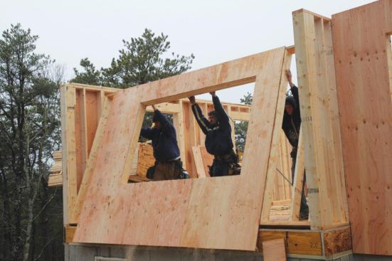 When the crew raises the wall, the sheathing at the bottom of the wall covers the rim joist.