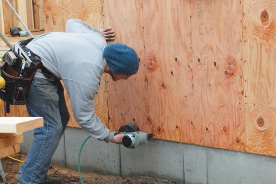 Certain sections of the walls on this house were engineered to increase their racking strength. Placement of the sheets meant that small strips needed to be filled in after the walls were raised. Short jogs were also raised without sheathing and were filled in afterwards.